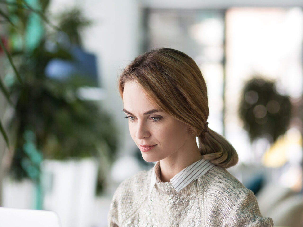 professional woman typing on laptop while building her LinkedIn personal brand