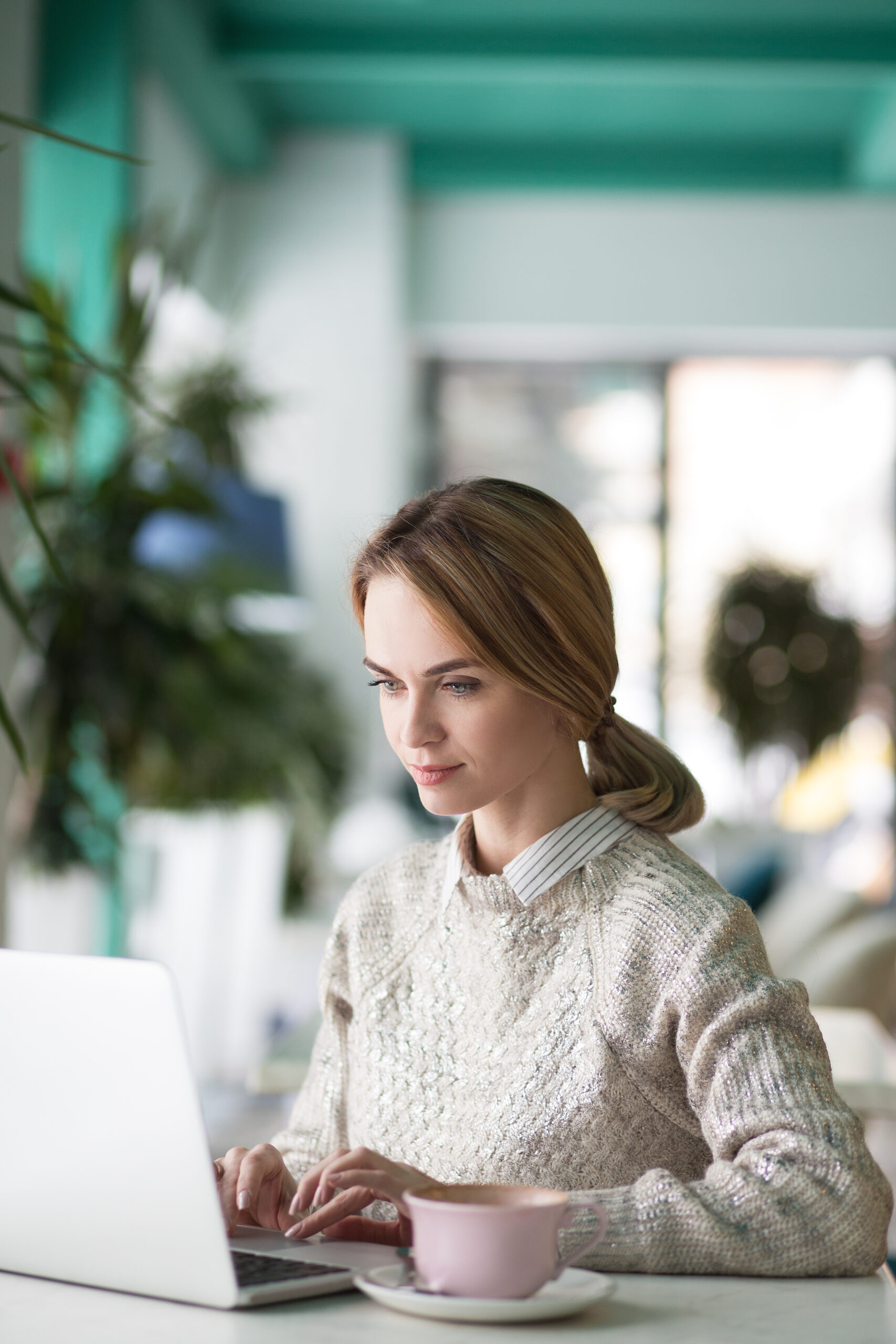 professional woman typing on laptop while building her LinkedIn personal brand